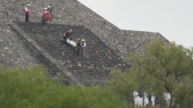 Trabalhadores forenses carregam o corpo de uma vítima para baixo de uma pirâmide depois que as autoridades disseram que um homem armado abriu fogo, em Teotihuacan, México, na segunda-feira.