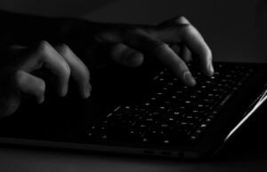 Backups do iCloud direcionados à operação de hack-for-hire usando páginas falsas da Apple Apple alerta usuários de iPhone em 100 países que são vítimas de spyware | Foto assustadora e discreta em preto e branco de mãos digitando em um teclado