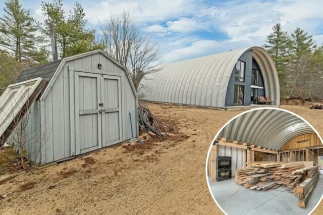 Uma casa em estilo cabana Quonset com exterior inacabado e um pequeno galpão na frente.