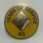 Um homem afirma que sua mãe recebeu este distintivo e flores por 45 anos de serviço no Commonwealth Bank.