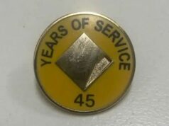 Commonwealth Bank sob ataque por causa deste pequeno alfinete amarelo Um homem afirma que sua mãe recebeu este distintivo e flores por 45 anos de serviço no Commonwealth Bank.