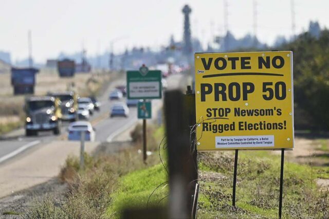 Uma placa amarela na beira de uma estrada que diz 