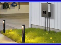 Como atualizar sua iluminação externa sem contratar um profissional Um conjunto de transformador e luzes de caminho mostrado com uma caixa de transformador de metal escovado montada em uma casa e luzes de caminho iluminando um caminho de jardim à noite com pessoas reunidas ao fundo.