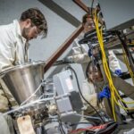 Grande maquinaria com vários contentores descendentes cobertos de fios.