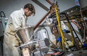 Como os pesquisadores do norte de Ontário estão usando tecnologia movida a bactérias para extrair minerais essenciais de resíduos de minas Grande maquinaria com vários contentores descendentes cobertos de fios.