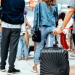 Um avião amarelo da Spirit Airlines decola, sobrevoando montanhas cobertas de neve sob um céu nublado.