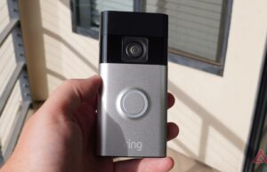 Compre uma campainha com vídeo Ring por apenas US $ 14 Uma campainha com câmera branca montada ao lado de uma porta branca, encostada em uma parede vermelha ousada com padrões geométricos.