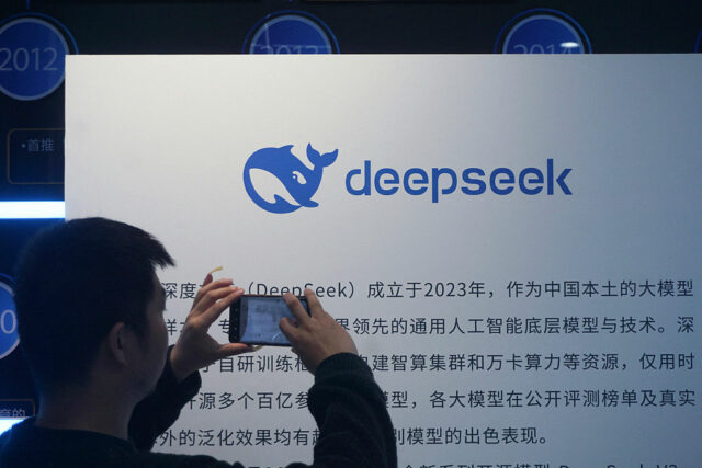 A man takes photos of a DeepSeek display at a shopping mall in Hangzhou