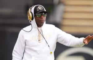 Deion Sanders diz que está com boa saúde durante o jogo de primavera do Colorado Deion Sanders, técnico do Colorado Buffaloes, com capuz branco, chapéu, óculos escuros e fones de ouvido dourados, em campo.