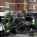 An official works among the burnt out ambulances at the scene of an antisemitic arson attack in the Golders Green neighbourhood of north London, on March 24, 2026.