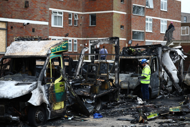 An official works among the burnt out ambulances at the scene of an antisemitic arson attack in the Golders Green neighbourhood of north London, on March 24, 2026.