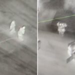 Imagem térmica de um helicóptero da polícia mostrando duas figuras em uma estrada, suspeitas de roubo de fios de cobre.