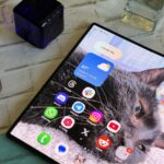 Três smartphones dobráveis ​​da Huawei, Apple e Samsung flutuando sobre um fundo azul.