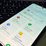 Tela exibindo uma interface de desktop do Android com um Google Pixel próximo a ele e alguns mascotes do Android em segundo plano