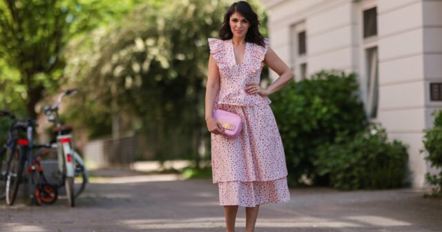 Aline Kaplan vestindo calças jeans azuis de perna larga Baum & Pferdgarten e outras histórias blusa cortada com padrão de flores brancas e salto laranja de verão e tons laranja preto Mango em 06 de junho de 2023 em Berlim, Alemanha.