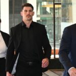 O ex-jogador do NRL Curtis Scott (centro) chega ao Downing Center District Court, em Sydney, quarta-feira, 8 de abril de 2026.