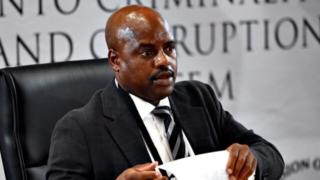 Ex-chefe de polícia sul-africano fica com lenço preso na testa Ex-chefe de polícia sul-africano fica com lenço preso na testa enquanto suava durante investigação de corrupção