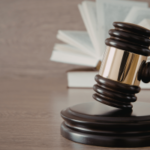 Ex-oficial de liberdade condicional da Filadélfia condenado por administrar negócios ilegais de jogos de azar esportivos. Martelo apoiado em bloco de madeira com documentos legais