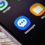 Mão monocromática segurando uma lupa sobre o logotipo AP/Google Mensagens/ícones de Mensagens Samsung