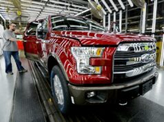 Ford faz recall de mais de 1 milhão de picapes F-150 devido a riscos de colisão associados a defeito na mudança de marcha Um trabalhador inspeciona um caminhão Ford F-150 vermelho com a porta aberta em uma fábrica de montagem.