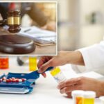 Uma pessoa de terno segurando um martelo de madeira acima de um bloco de ressonância.