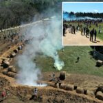 Vista aérea de ativistas dos direitos dos animais reagindo ao gás lacrimogêneo durante um protesto.