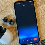 Alguém segurando um Samsung Galaxy S25 Ultra com Gemini Live ativado em frente a uma parede com vários porta-retratos