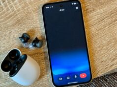 Gemini Live acabou com resumos de notícias chatos Alguém segurando um Samsung Galaxy S25 Ultra com Gemini Live ativado em frente a uma parede com vários porta-retratos