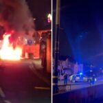 Um veículo pegou fogo em uma rua à noite.