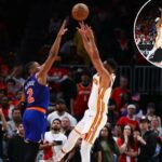Os jogadores de basquete CJ McCollum e Miles McBride saltam para pegar a bola durante um jogo dos Playoffs da NBA.