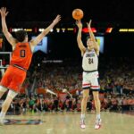 O armador do UConn Huskies, Braylon Mullins (24), chutou a bola contra o atacante do Illinois Fighting Illini, David Mirkovic (0), durante o jogo Final Four.