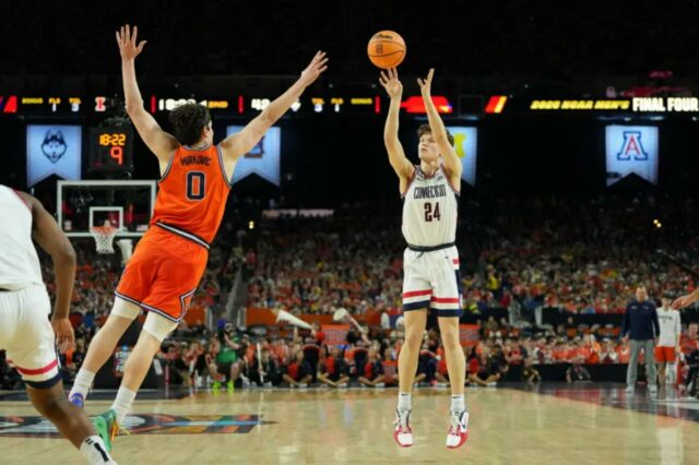O armador do UConn Huskies, Braylon Mullins (24), chutou a bola contra o atacante do Illinois Fighting Illini, David Mirkovic (0), durante o jogo Final Four.