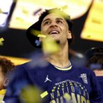 Yaxel Lendeborg, do Michigan Wolverines, olha para cima com um leve sorriso enquanto confetes caem ao seu redor.