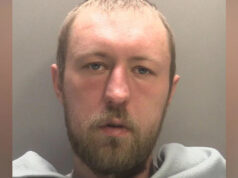 Homem condenado à prisão perpétua por estupro e agressão religiosamente agravada de mulher Sikh Um homem com um anoraque com capuz inspeciona um graveto encostado em uma cerca viva à noite