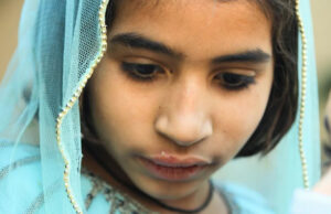 Hospital no centro do surto de HIV infantil é pego reutilizando seringas em filmagem secreta Um homem sentado em uma cadeira usando um estetoscópio, máscara facial e luvas cumprimenta uma mulher segurando seu filho. Os rostos da mulher e da criança estão obscurecidos.