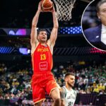 Um jogador de Montenegro com camisa vermelha com o número 13 enterrou a bola no aro durante um jogo do FIBA ​​​​EuroBasket 2025 contra a Lituânia.