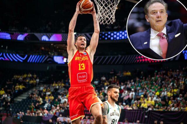 Um jogador de Montenegro com camisa vermelha com o número 13 enterrou a bola no aro durante um jogo do FIBA ​​​​EuroBasket 2025 contra a Lituânia.