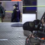 Dois policiais de Iowa City atrás da fita da cena do crime.