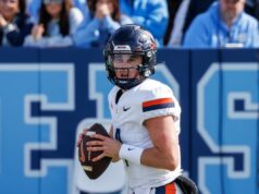 Juiz nega oferta de Virginia QB Chandler Morris para o sétimo ano de elegibilidade para a faculdade Chandler Morris vestindo uma camisa de futebol branca da Virgínia e capacete preto, segurando uma bola de futebol.