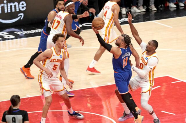O armador do New York Knicks, Jalen Brunson (11), chuta sobre o atacante do Atlanta Hawks, Jonathan Kuminga (0), durante o terceiro quarto do jogo 3 dos playoffs da NBA.
