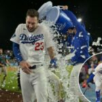 O defensor direito do Los Angeles Dodgers, Kyle Tucker (23), é encharcado com água gelada de um refrigerador pelo defensor direito Alex Call (12) após o single de saída de Tucker.
