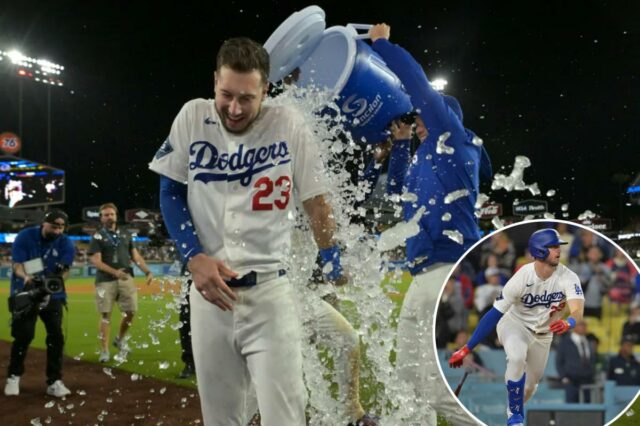 O defensor direito do Los Angeles Dodgers, Kyle Tucker (23), é encharcado com água gelada de um refrigerador pelo defensor direito Alex Call (12) após o single de saída de Tucker.