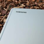 Samsung Galaxy S25 deitado de bruços sobre uma mesa com o logotipo da Samsung visível