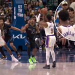 LeBron James, com a camisa do Lakers, gesticula com os braços cruzados enquanto conversa com seu filho, Bronny James Jr., com a camisa do Lakers.