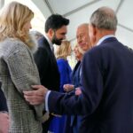 Rei Carlos III e Rainha Camilla interagindo com convidados em evento.