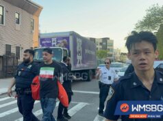 Maníaco com camiseta com bandeira iraniana esmurra três homens judeus em crime de ódio em Nova York: fontes Dois policiais e outros homens em uma rua do Brooklyn, com um