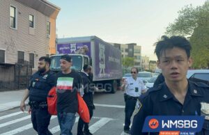 Maníaco com camiseta com bandeira iraniana esmurra três homens judeus em crime de ódio em Nova York: fontes Dois policiais e outros homens em uma rua do Brooklyn, com um