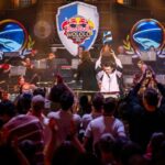 A man holding a trophy aloft in front of a crowd