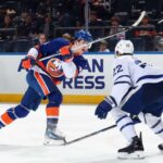Matthew Schaefer #48 do New York Islanders dá um arremesso de primeiro período contra Jake McCabe #22 e o Toronto Maple Leafs na UBS Arena em 09 de abril de 2026 em Elmont, Nova York.