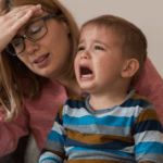 Uma mulher estressada e uma criança chorando.